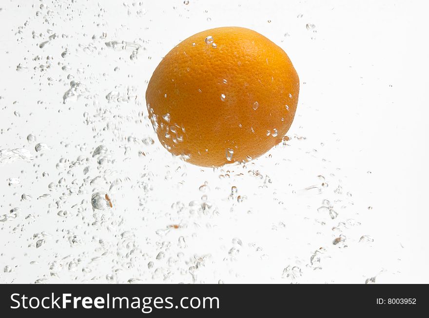 Alone orange  is dropped into fresh water. Alone orange  is dropped into fresh water