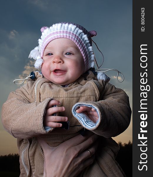Little baby outdoors on blue sky background