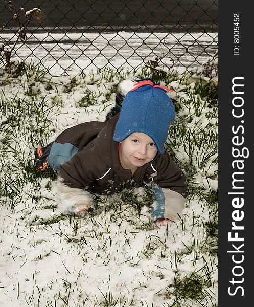 Little boy playing in the snow in the garden. Little boy playing in the snow in the garden.