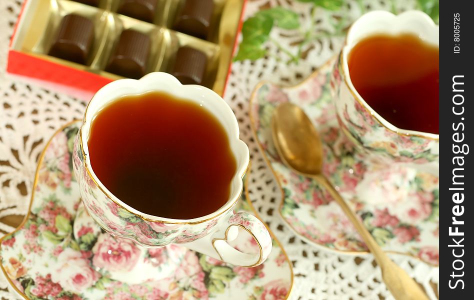 Cup of tea and chocolates on knitted table cover, coseup