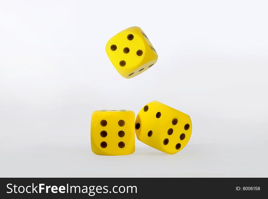 Gambling with three yellow dice,isolated over white.