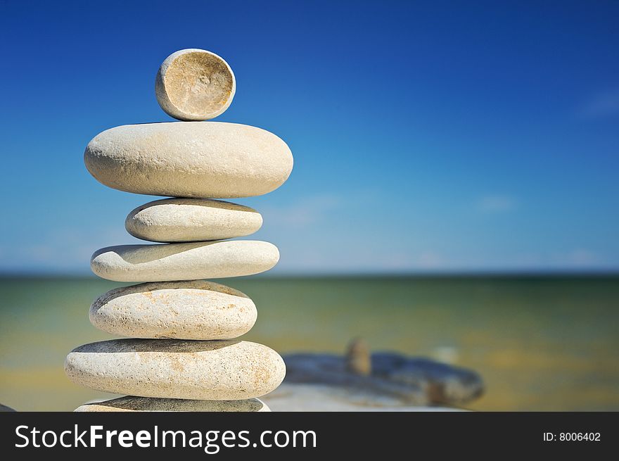 Small round stone at top of a pile of sea stones. Small round stone at top of a pile of sea stones