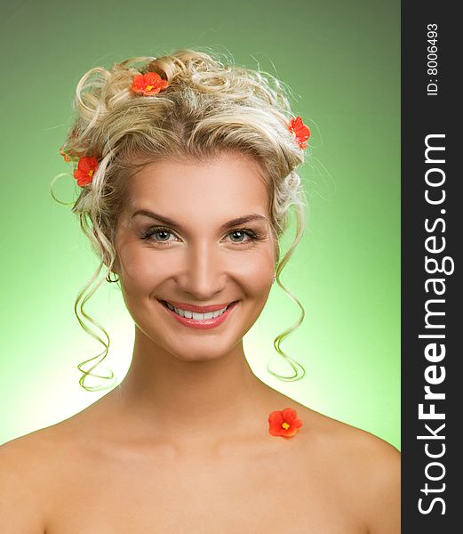 Beautiful young woman with fresh spring flowers in her hair. Spring concept.