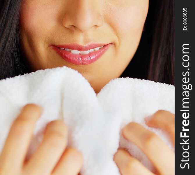 Close up of a woman hugging and smelling a fresh white towel. Close up of a woman hugging and smelling a fresh white towel.