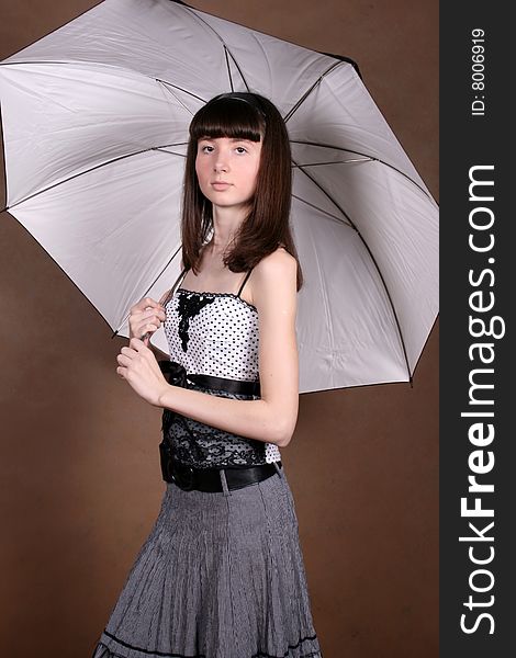 Girl standing in studio with an umbrella. Girl standing in studio with an umbrella