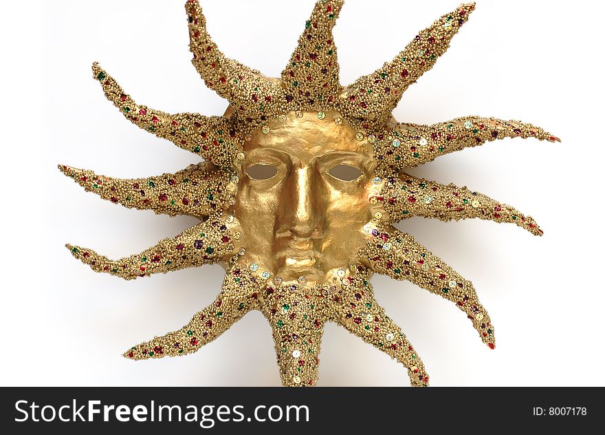 Golden mask of sun decorated with tinsel