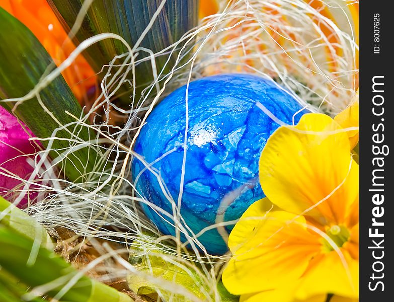 Blue easter egg in a basket with a flower