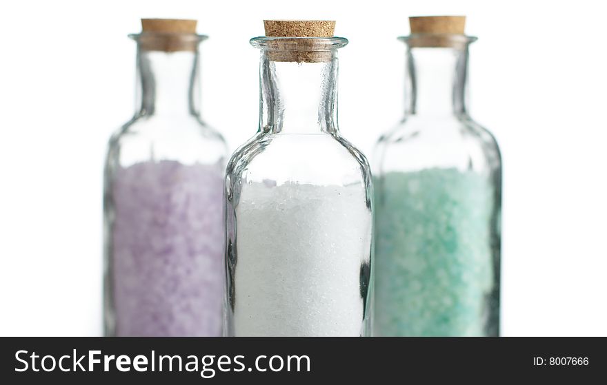 Colored bath salt against a white background.