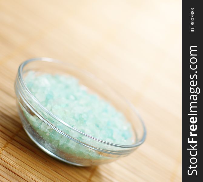 Colored bath salt displayed on top of a bamboo mat.