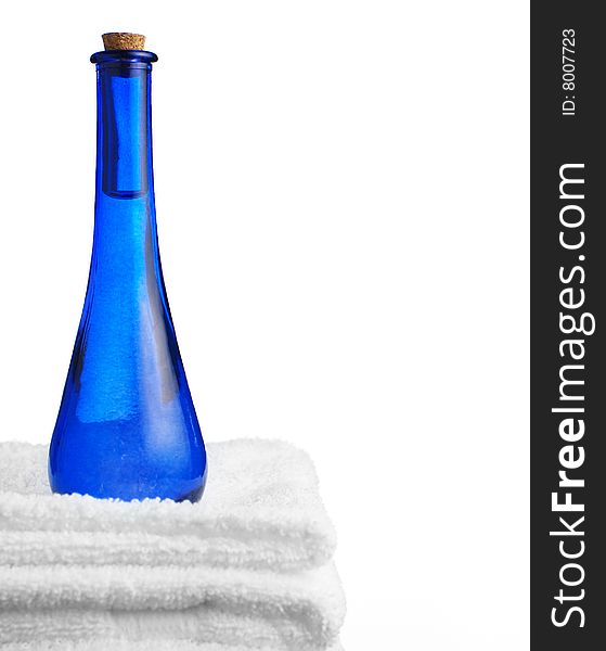 Blue glass corked bottle and towels against white. Blue glass corked bottle and towels against white.