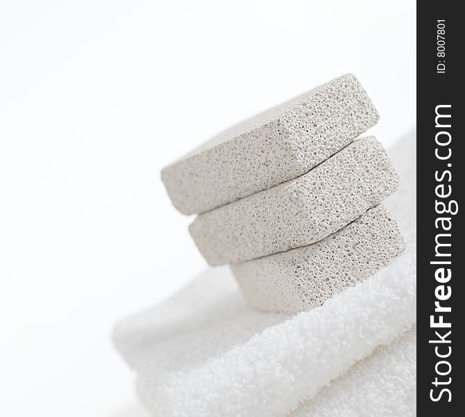 Pumice stones on towels against a white background. Pumice stones on towels against a white background.
