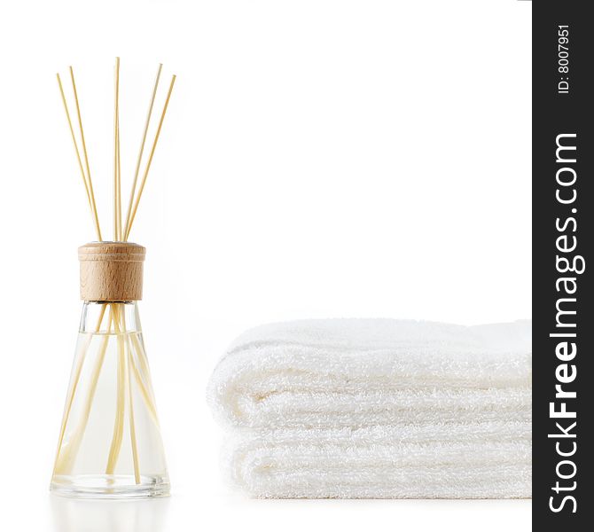 Diffuser and stack of towels against a white background. Diffuser and stack of towels against a white background.