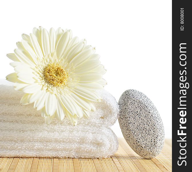 Towels, pumice stone, and flower against a white background. Towels, pumice stone, and flower against a white background.