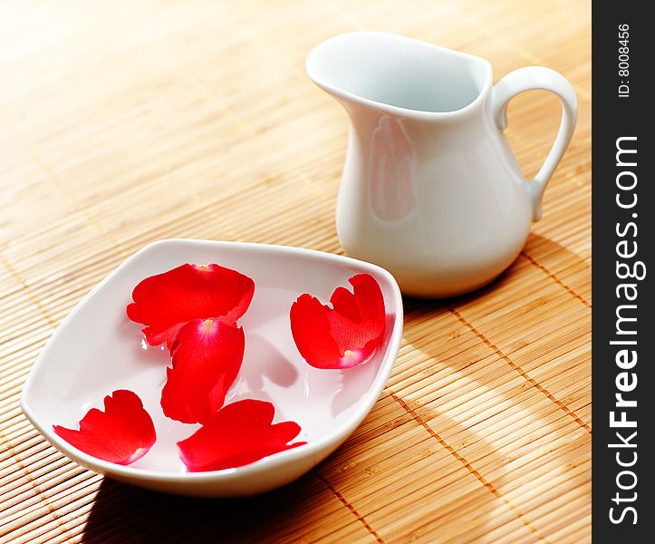 Pitcher, water, and floating rose petals. Pitcher, water, and floating rose petals