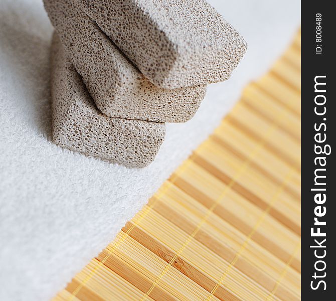 Pumice stones and towel against bamboo reed mat. Pumice stones and towel against bamboo reed mat.