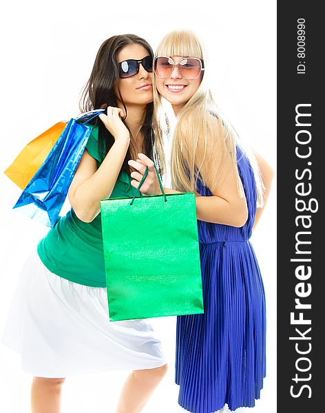 Two beautiful young women with shopping bags against white background. Two beautiful young women with shopping bags against white background