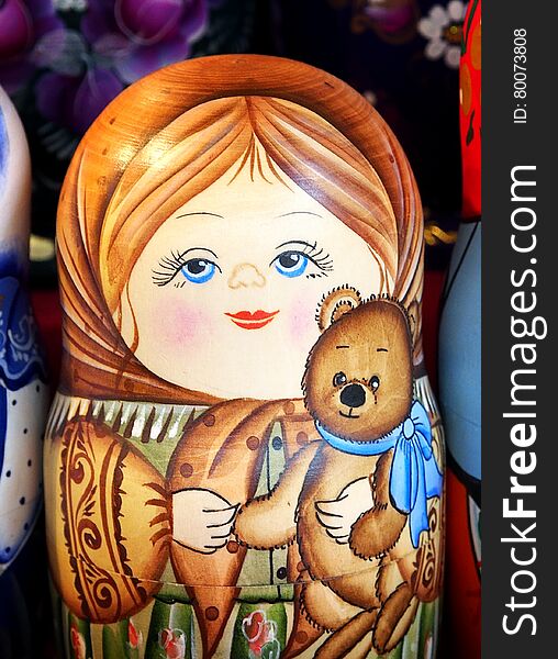 Matrioska representing a young girl with a toy bear. On sale in a christmas street market. Matrioska representing a young girl with a toy bear. On sale in a christmas street market.