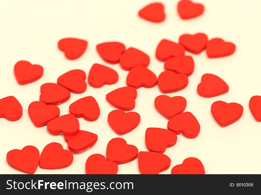 A lot of small wooden hearts put on white background. A lot of small wooden hearts put on white background