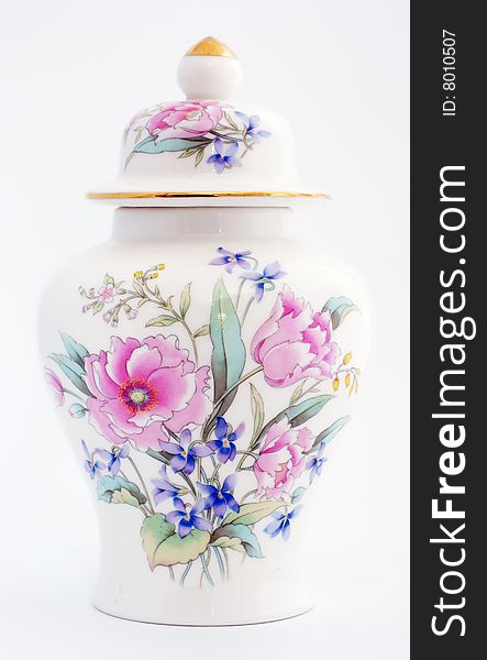 Oriental ginger jar with a floural motiff. Roses and other colorful flowers adorn the front of the jar, the lid has a gold top and a gold rim.