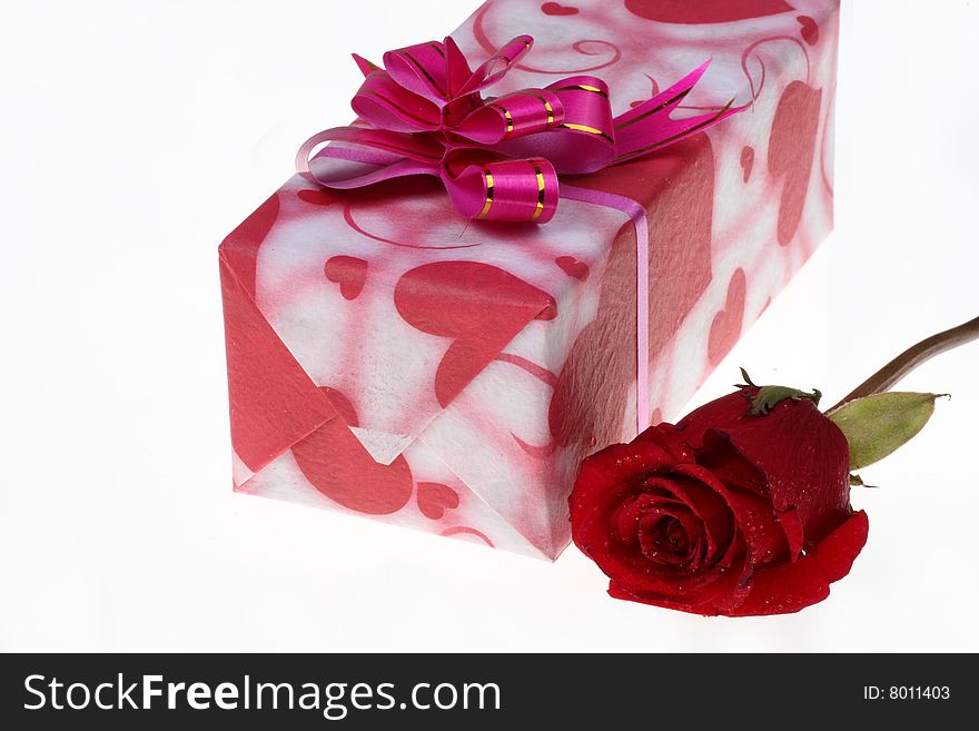Beautiful gift box and a rose are on white background.