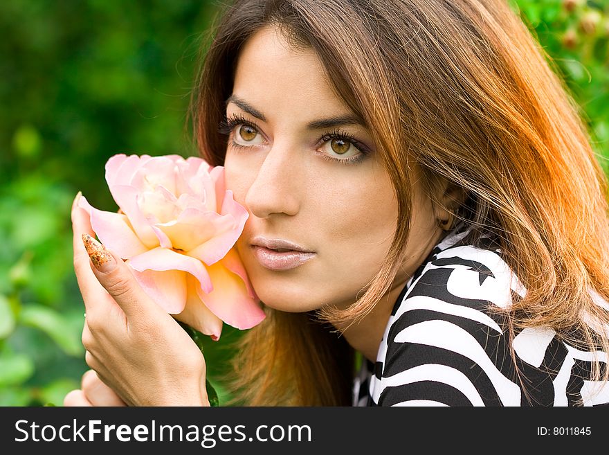 Beautiful woman in garden with roses