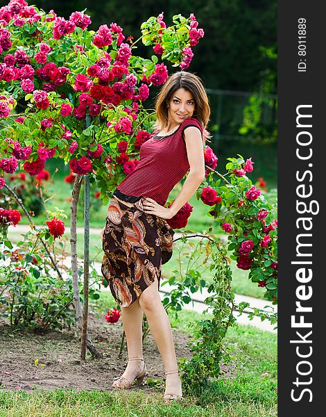 Beautiful woman in garden with roses