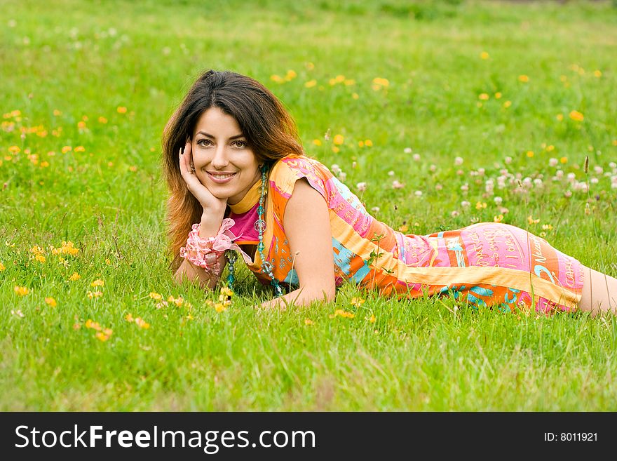 Beautiful woman lies on a grass in the field