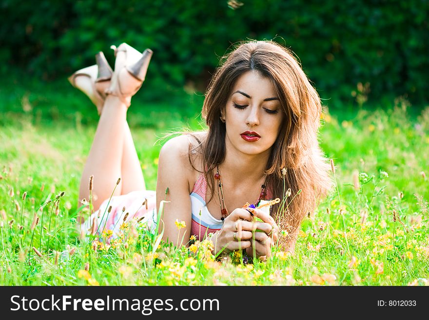 Beautiful woman lies on a grass in the field