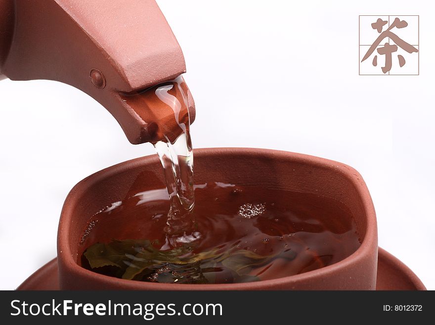 Green tea pouring into tea cup from teapot on white background. Chinese on the picture is tea. Green tea pouring into tea cup from teapot on white background. Chinese on the picture is tea.