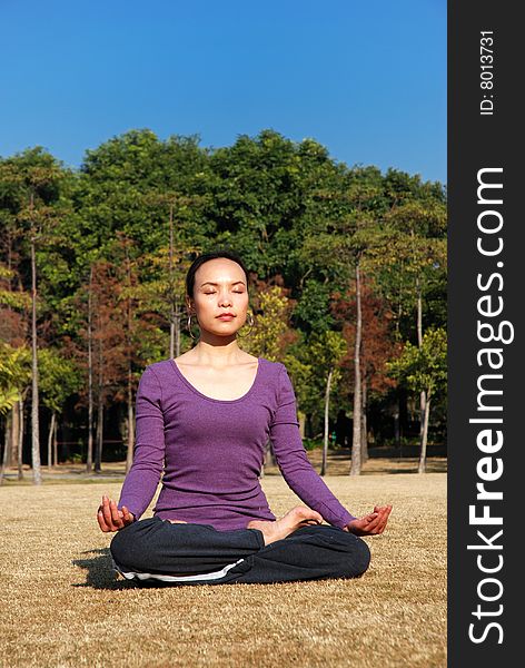 Young Asian Woman exercising Yoga in the park