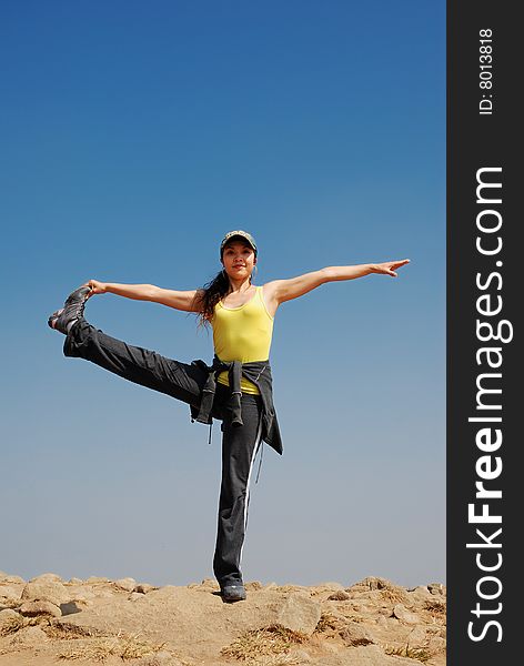 Young Asian Woman exercising Yoga against blue sky