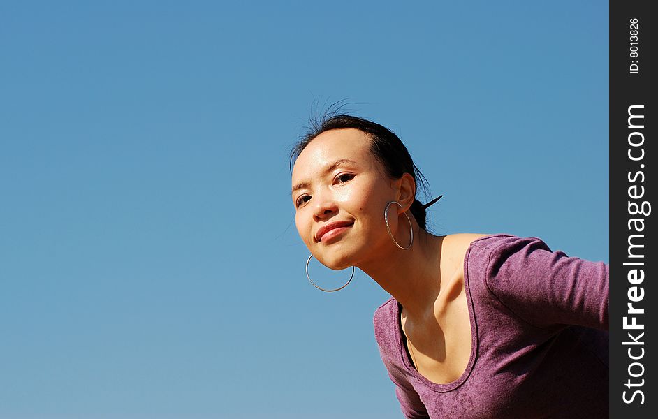 Young asian woman with beautiful smile on blue sky background. Young asian woman with beautiful smile on blue sky background