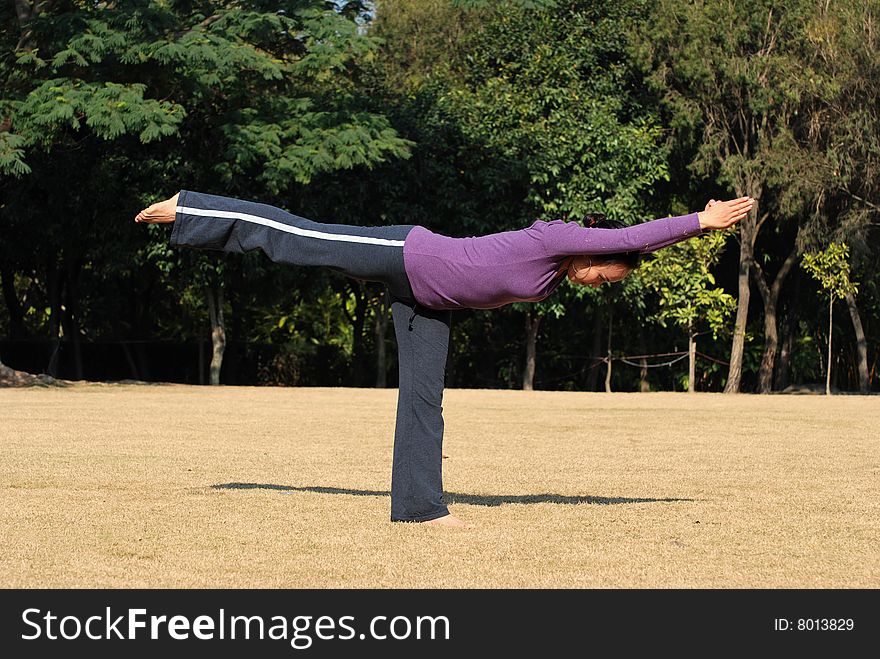 Young Asian Woman exercising Yoga in the park