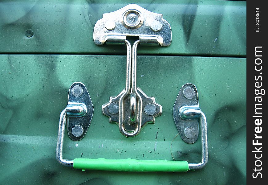 A steel latch and a handle on a green steel trunk