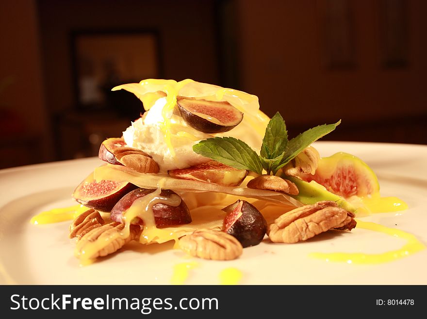 Phyllo pastry with fruit and nuts covered in a lemon sauce and a peppermint leaf