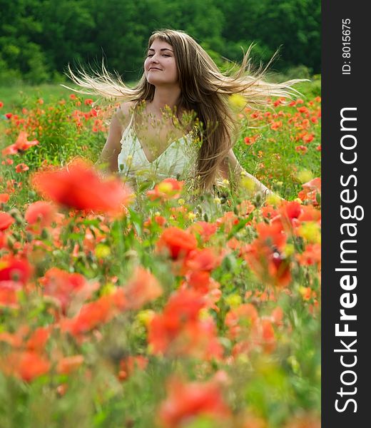 Young girl with long hair in poppies field