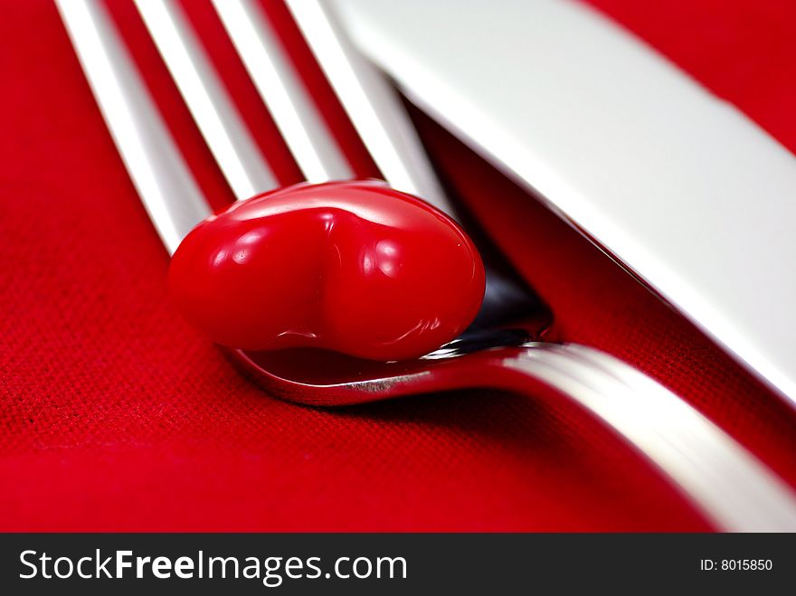 Red heart and cutlery on a red napkin. Red heart and cutlery on a red napkin
