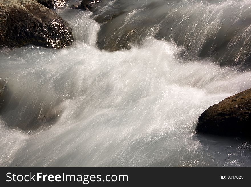 Waters of a river flowing between the rocks. Waters of a river flowing between the rocks