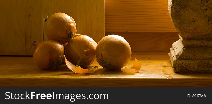 Still life with onion on wood and old vase