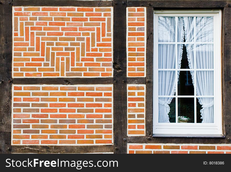Wall of bricks and wood, window with a curtain. Wall of bricks and wood, window with a curtain