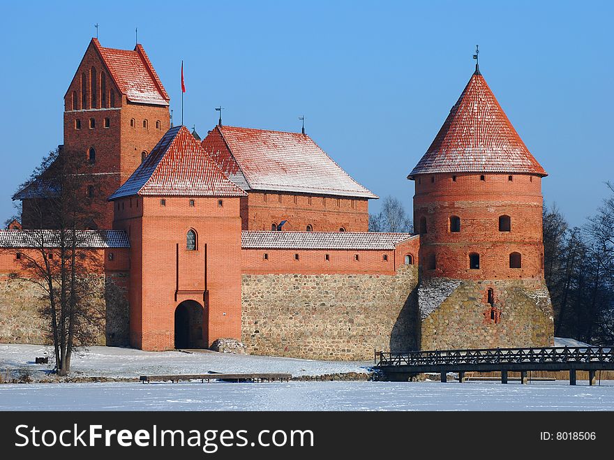 Medieval castle in the middle of the frozen lake in winter blue sky background. Medieval castle in the middle of the frozen lake in winter blue sky background