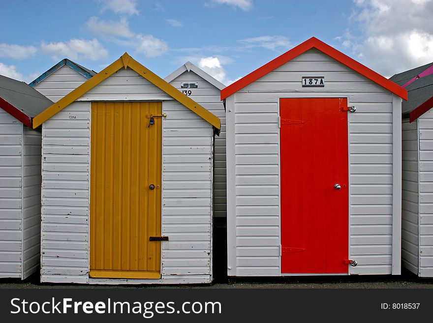 Wooden beach huts with multi colored doors