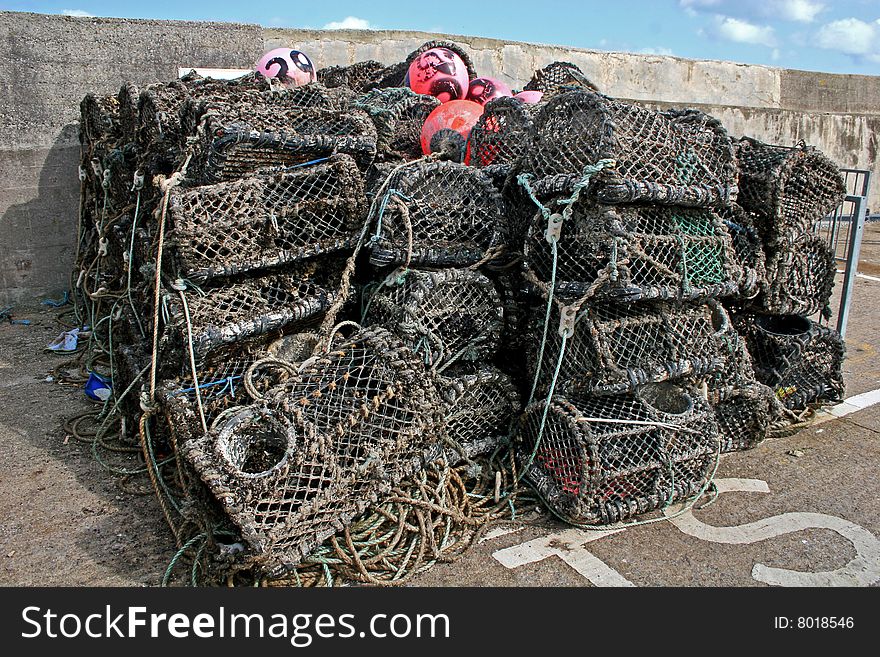 Stack of lobster pots on harbor wall