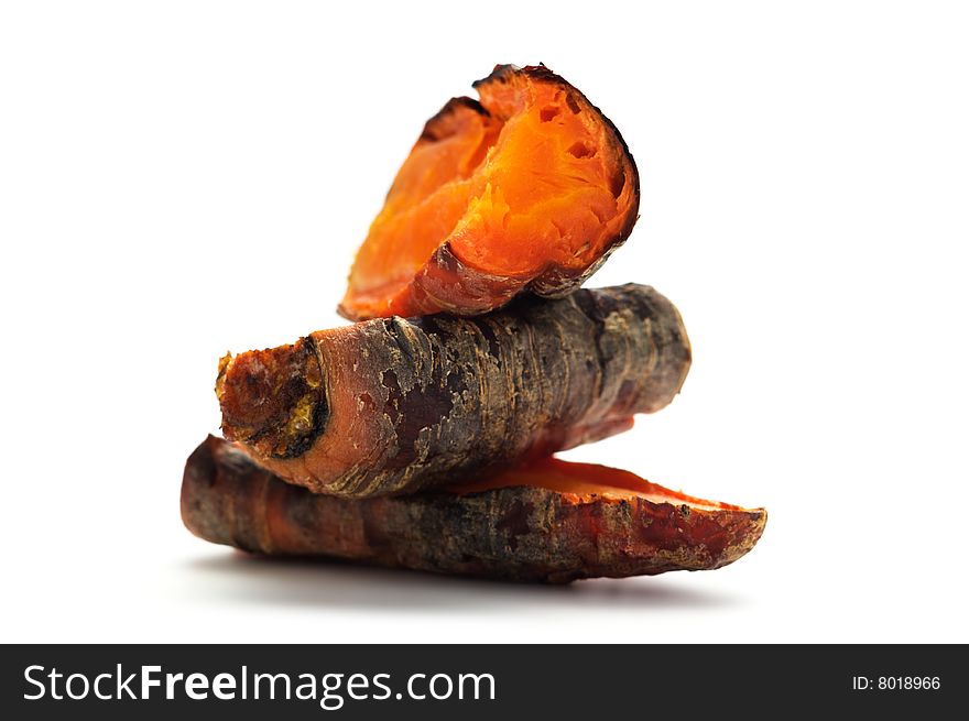 Grilled carrot cut into pieces and stacked in a pile. Isolated on a white background.