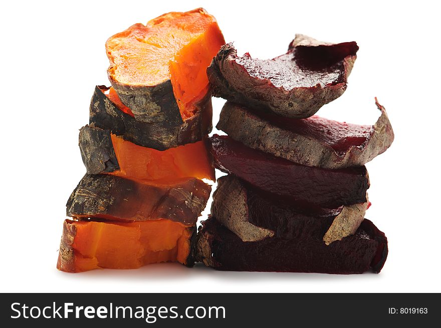 Grilled beet and carrot cut into pieces and stacked in a pile. Isolated on a white background. Grilled beet and carrot cut into pieces and stacked in a pile. Isolated on a white background.