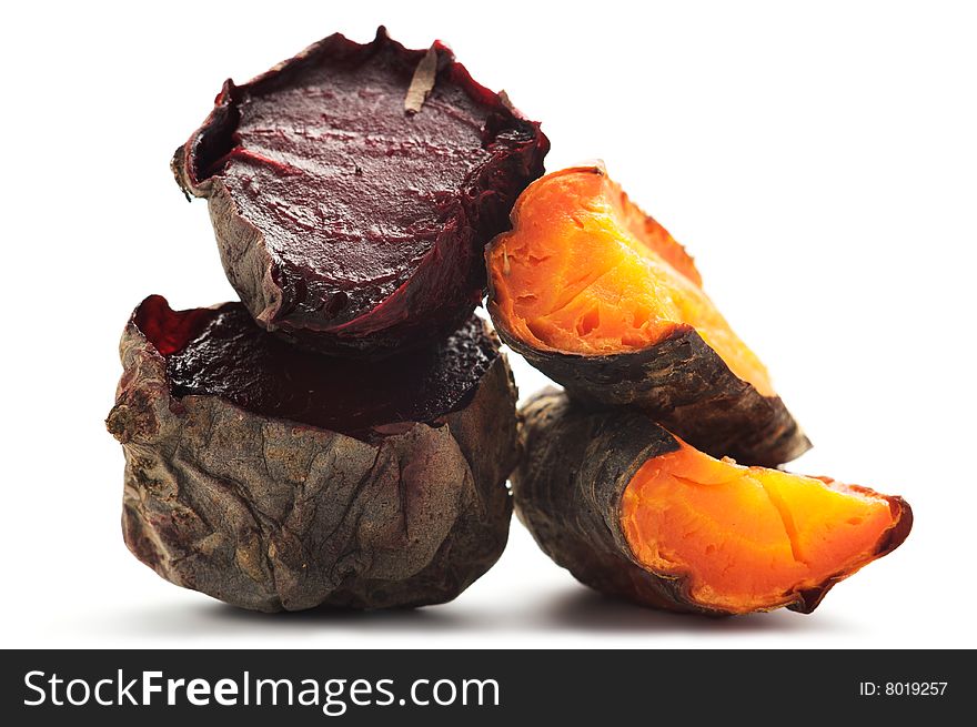 Grilled beet and carrot cut into pieces and stacked in a pile. Isolated on a white background. Grilled beet and carrot cut into pieces and stacked in a pile. Isolated on a white background.