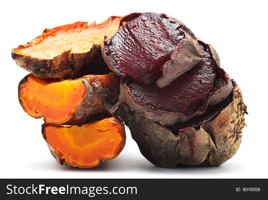 Grilled beet and carrot cut into pieces and stacked in a pile. Isolated on a white background.