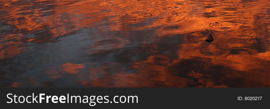 Orange glow of sunset reflected on water. Orange glow of sunset reflected on water