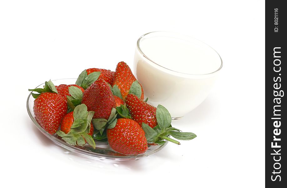 Glass cup with milk and a strawberry. A still-life on a white background. Glass cup with milk and a strawberry. A still-life on a white background.