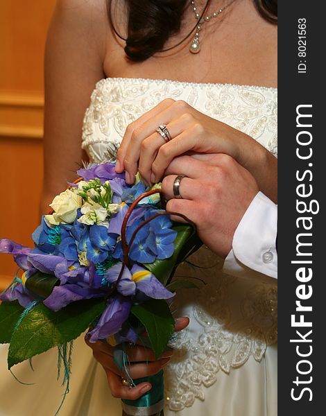 Bride and groom with hands over flowers. Bride and groom with hands over flowers